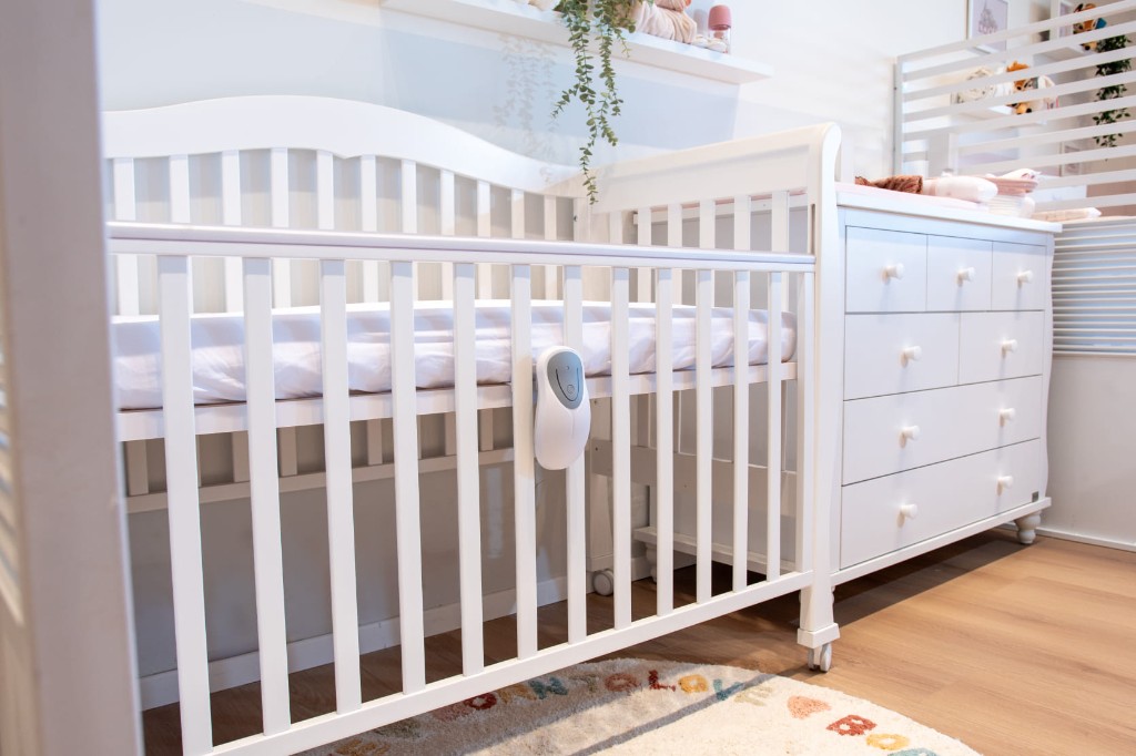 Babysense 8 - kontrolná jednotka pripevnená na bielu detskú postieľku
